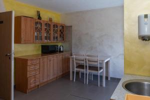 a kitchen with wooden cabinets and a table and chairs at Guest house Ieva in Šventoji