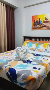 two swans are forming a heart on a bed at Gerbi's Condoplace at Oceanway Residences in Sampong