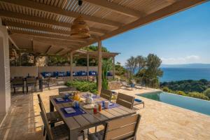 a dining table on a patio with a view of the ocean at Villa Filakia in Ratzakli in Ratzaklíon