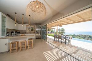 a kitchen and dining room with a view of the ocean at Villa Filakia in Ratzakli in Ratzaklíon