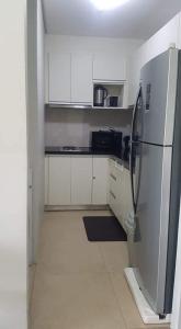 a kitchen with white cabinets and a refrigerator at Gerbi's Condoplace at Oceanway Residences in Sampong
