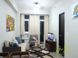 a living room with a couch and a tv at Gerbi's Condoplace at Oceanway Residences in Sampong