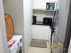 a small kitchen with a washer and dryer at Gerbi's Condoplace at Oceanway Residences in Sampong