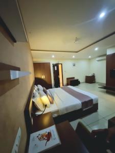 a hotel room with a bed and a desk with a table sidx sidx at Emperorhotel in Jāmb