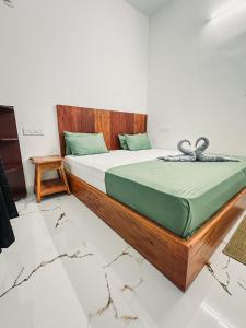 a bedroom with a bed with a wooden headboard at Kuma Surf House in Kappil