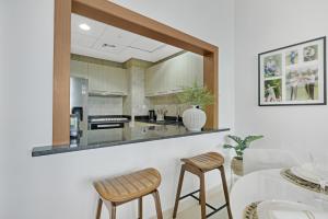 cocina con encimera con 2 sillas y mesa en The Green Keepers Look-out, en Abu Dabi