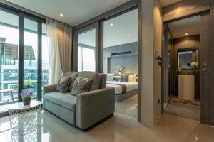 a bedroom with a bed and a couch in a room at C118 Rooftop Pool Condo Walk to Beach, Gym, Wi-Fi in Kamala Beach +41 photos