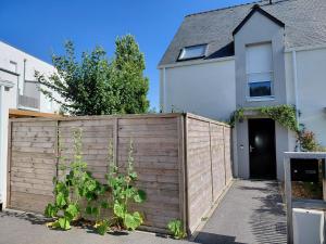 a wooden fence in front of a house at Maison avec jardin privatif pour 4 a 7 personnes proche de la plage bonne source in Pornichet
