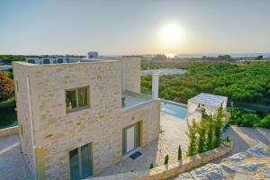 法拉萨纳Koukis Villa With Sea View的享有石头房子空中美景,设有游泳池