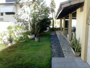 a garden with potted plants on the side of a house at Pousada Porto Villas in Lauro de Freitas