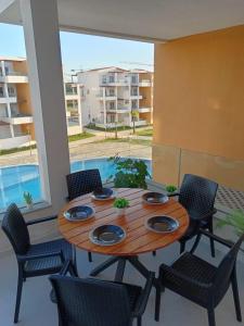 a wooden table and chairs on a patio with a pool at Cabo zen suites in Cabo Negro +15 photos