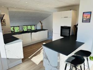 a kitchen with black counter tops and white cabinets at Villa Centrum in Holstebro