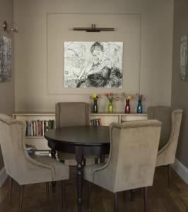 a room with a table, chairs, and a painting on the wall at Bohema, Tubinas Hotels in Klaipėda