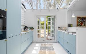 Una cocina con gabinetes azules y un tragaluz. en 3 Bedroom Amazing Home In Hornbæk, en Hornbæk