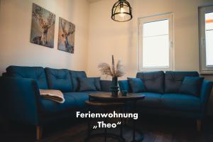 a living room with a blue couch and a table at Stadtvilla Haug die exklusiven Ferienwohnungen im Harz in Blankenburg
