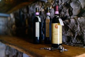 three bottles of wine sitting on a wooden shelf at Crotto Di Gittana in Perledo