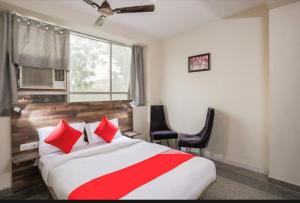 a hotel room with a large bed with red pillows at solstice suites in Faridabad