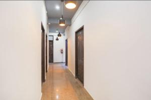 a hallway with white walls and a black door at solstice suites in Faridabad