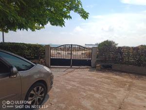 a car parked in front of a gate with a dog at La maison à la mer de Mamé Rosette in Port-de-Bouc