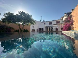 a pool of water in front of a building at Can Vilàs in Muro