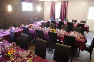 ein Zimmer mit Tischen und Stühlen mit lila Tischdecken in der Unterkunft LOGIS-Hôtel Restaurant Auberge Les Vallées Du Perche in Vichères