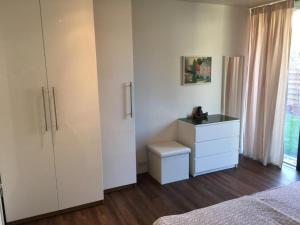 - une chambre avec une commode et une armoire blanche dans l'établissement See und Mehr Apartment 2, à Stetten