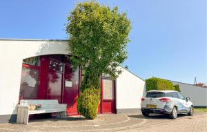 a car parked in front of a building with a red door at 2 Bedroom Lovely Home In Lemmer in Lemmer +7 photos