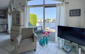 a living room with a tv and a chair and a window at 2 Bedroom Lovely Home In Lemmer in Lemmer