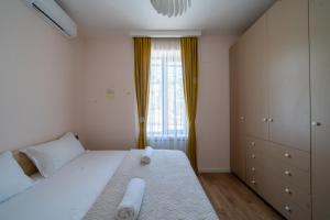 a bedroom with a large white bed and a window at Niabi Villa with pool in Tbilisi City +10 photos