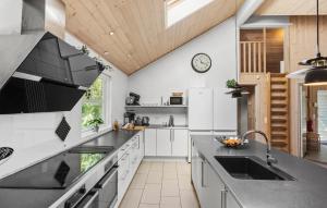 a kitchen with white appliances and a wooden ceiling at Pet Friendly Home In Idestrup With Sauna in Marielyst