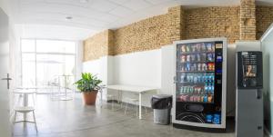 a drink refrigerator in a room with a table and chairs at Soho Valencia in Valencia