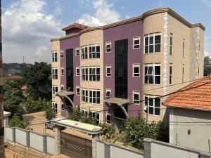 a purple building with a tennis court in front of it at Purple Deluxe Apartments in Kampala