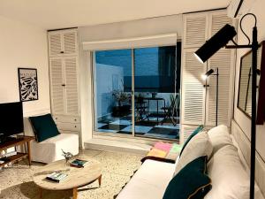 a living room with a white couch and a large window at Diseño y terraza en Punta del Este in Punta del Este