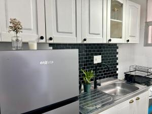 a kitchen with white cabinets and a sink at Diseño y terraza en Punta del Este in Punta del Este