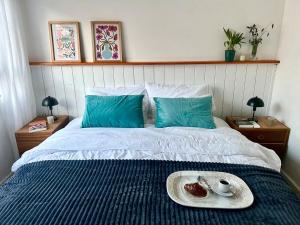 a bed with a tray with a plate of food on it at Diseño y terraza en Punta del Este in Punta del Este