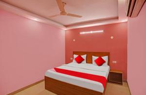 a bedroom with a bed with red and white sheets at solstice suites in Faridabad