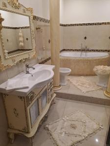 a bathroom with a sink and a tub and a mirror at Luxury House in Catania