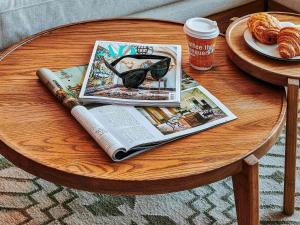 a table with a magazine and a book and a cup of coffee at 25hours Hotel Dubai One Central in Dubai