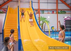 a group of children playing on a slide in a pool at Seaside caravan in Clacton-on-Sea +2 photos