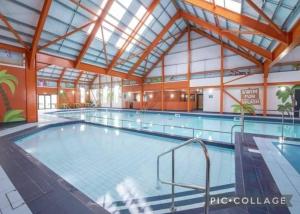 a large indoor swimming pool with a glass ceiling at Seaside caravan in Clacton-on-Sea