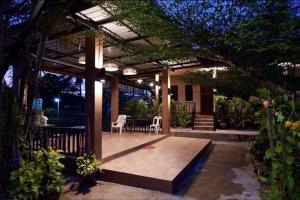 a patio with a table and chairs under a pergola at Hug Wang Homestay in Ban Nong Chaeng