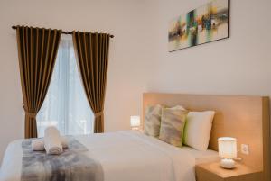 Ένα ή περισσότερα κρεβάτια σε δωμάτιο στο Radika Guest House Jimbaran