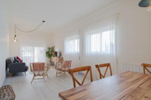 Una sala de estar con una mesa y sillas de madera. en Feel Nazaré - Ocean Villa, en Nazaré