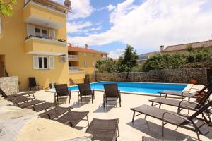 patio con sedie e piscina di Apartments Gorica 2 a Baška