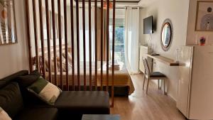 Una sala de estar con un sofá, una mesa y un refrigerador. en Καλαίσθητο Ηλιόλουστο Studio, en La Canea