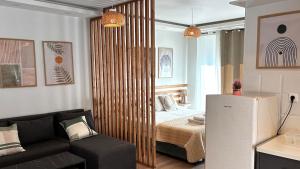 una sala de estar con un sofá y una cama en una habitación en Καλαίσθητο Ηλιόλουστο Studio, en La Canea