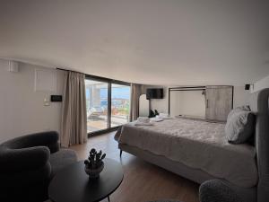 a bedroom with a bed and a couch and a table at Petra Mare - Sea View Escape in Nea Moudania in Nea Moudania