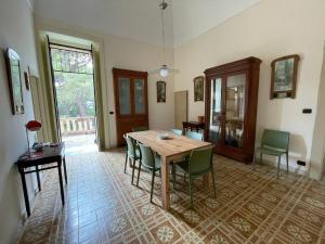 a dining room with a wooden table and chairs at Villa Del Prete in Nardò