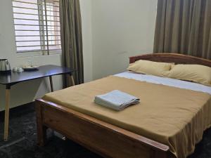 ティルヴァンナーマライにあるperumal home stayのベッドとテーブルと窓のある寝室