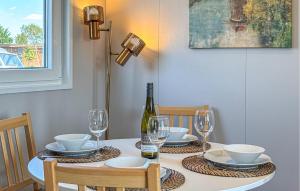 a dining room table with a bottle of wine and glasses at Nice Home In Breukelen in Breukelen
